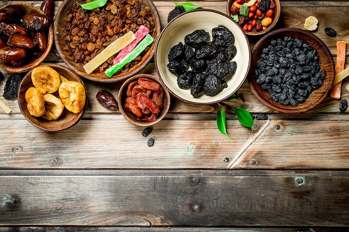 Assortment of different dried fruits in bowls.